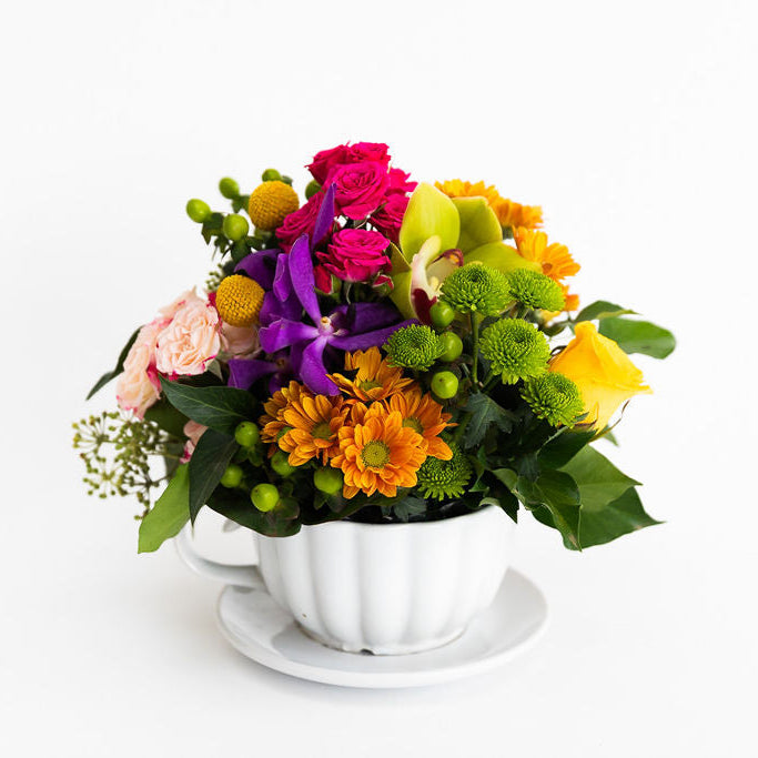 Colorful flower arrangement in a white teacup vase same day flower delivery melbourne