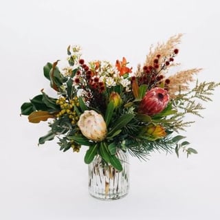 Wilderness - lush native style bouquet in vase, featuring pink or white protea, stirlingia, leucadendron, reed and gum foliage.