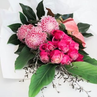 Pretty in pinks sheaf bouquet featuring pink roses, disbud chrysanthemums and anthuriums.