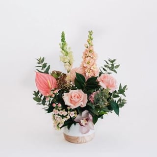 Ceramic vase arrangement featuring roses, stock, snapdragon, sims, orchid, hypericum and anthurium.