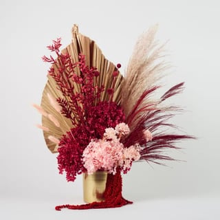 Rich jewelled with neutral dried and preserved flower arrangement in gold vase, features hydrangea, pampass, palm and amaranthus.
