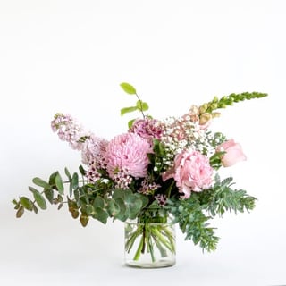 Sweet little pink vase arrangement featuring pink chrysanthemum disbud, rose, carnation, babies breath, waxflower/similar, stock, snapdragons.