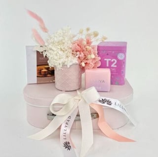 Mini dried and preserved flower arrangement in pinks and neutrals with chocolates, soap and tea suitcase hamper gift. Same day Melbourne delivery only.