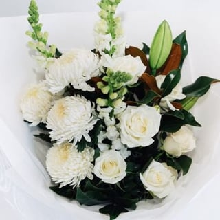 Elegant white bouquet featuring white disbud chrysanthemums, white oriental lilies, white snapdragons.