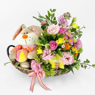 Plush bunny toy and flowers beautifully arranged in pinks and yellows