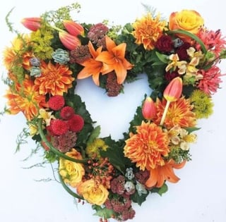 Sunset coloured funeral wreath featuring seasonal flowers, Melbourne delivery only.