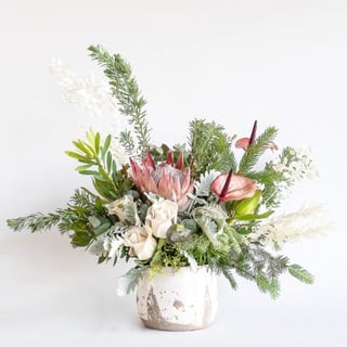Native rustic king protea flower arrangement with roses and anthuriums.