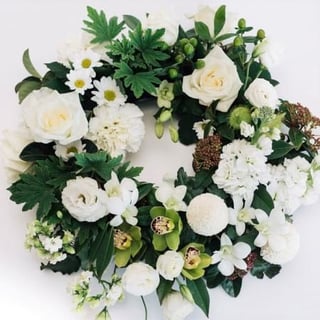 sympathy funeral wreath featuring white and green flowers including roses, cymbidium orchids, disbuds and seasonals to compliment. Melbourne same day delivery.