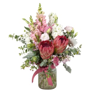 Pink and white snapdragons, stock flower, lisianthus and proteas in clear vase, available for same day delivery in Melbourne and Australia wide.