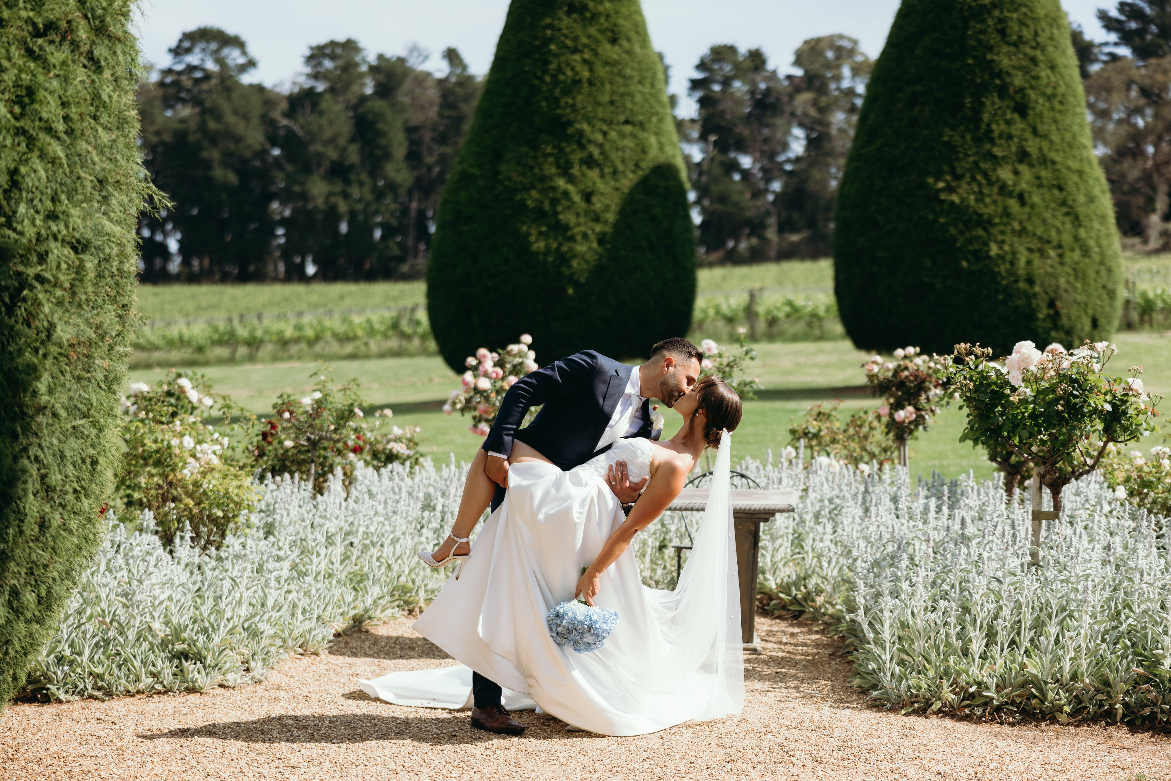 Bride and Groom Kiss Portrait in garden with roses and hydrangea