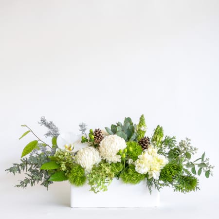 Floral arrangement with greenery and white flowers in a rectangular container center piece melbourne florist