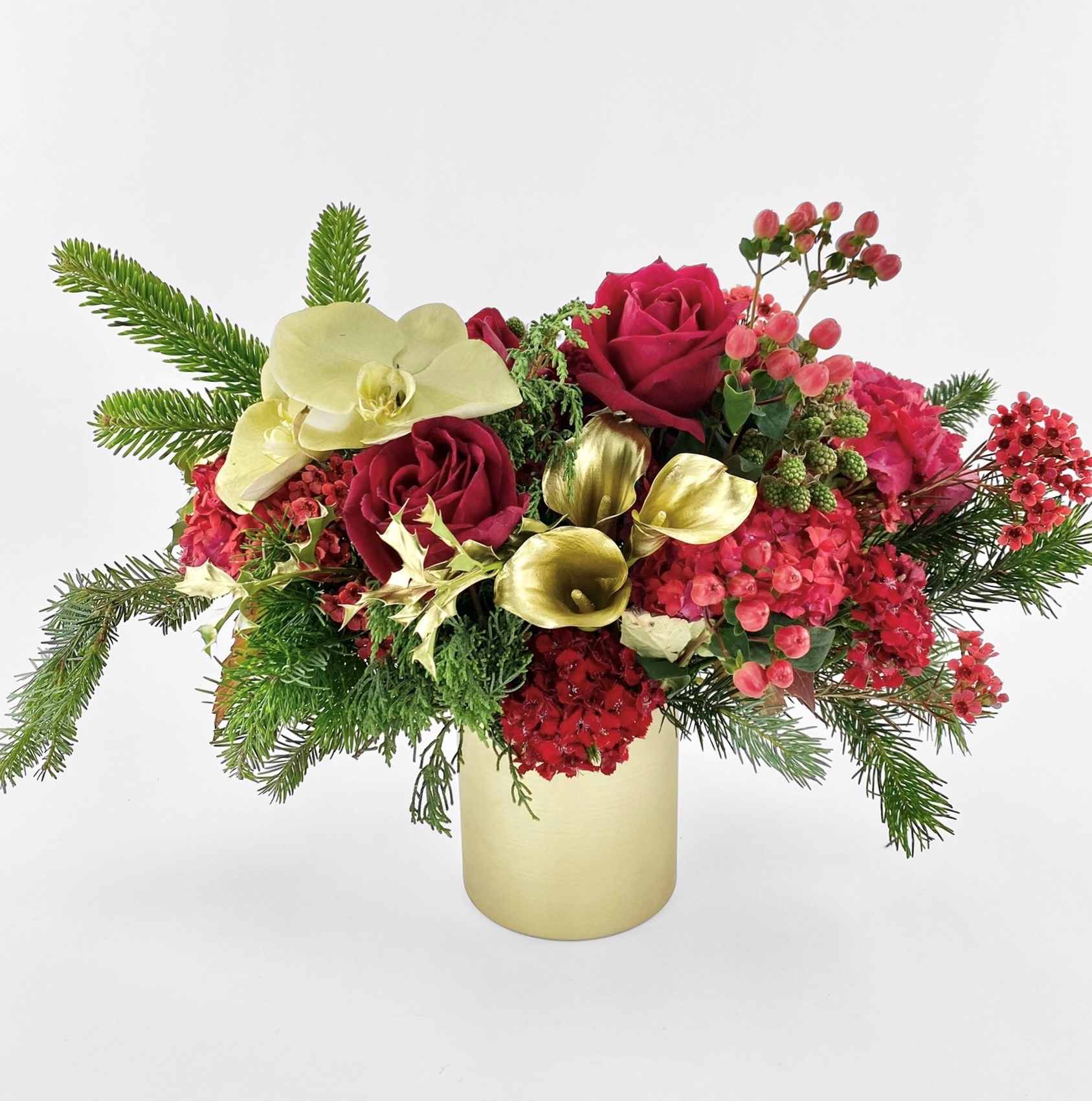 Gold pot Christmas centrepiece arrangement, red roses, Hypericum berry, hydranges and gold sprayed phalaenopsis orchids, calla lily and seasonal red flowers accented with fragrant pine leaves.