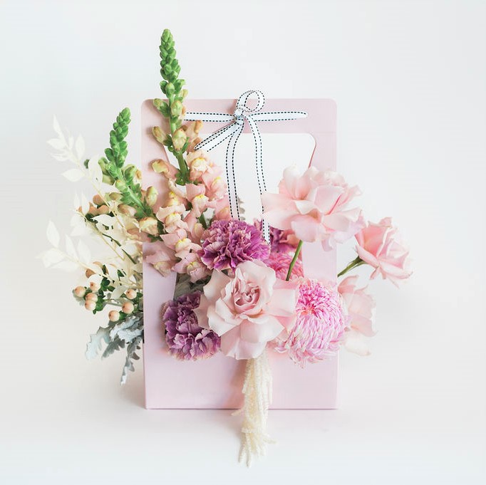 Perfect flower gift idea featuring pink carry box arrangement featuring pink reflexed roses, pink disbuds, pink snapdragons and pink carnations Melbourne delivery only.