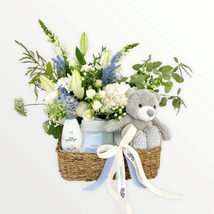 Gift basket filled with fresh flowers, teddy, beanie, bath soak for mother and baby.