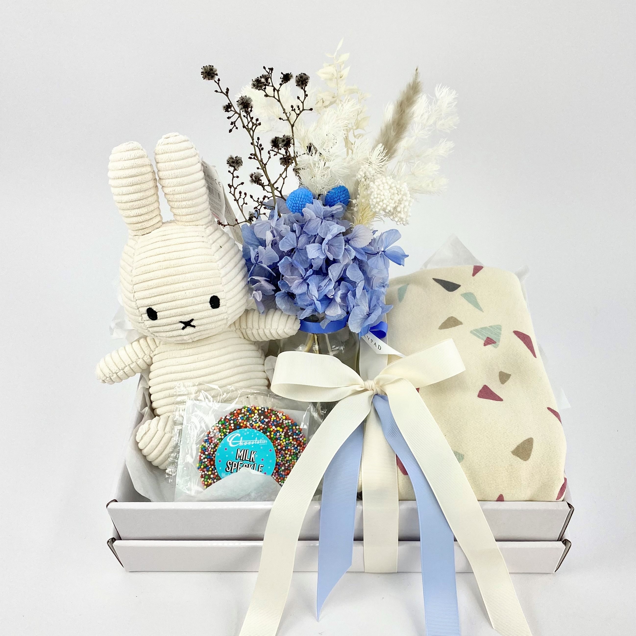 Gift hamper for new baby boy with baby blanket, preserved flowers in vase and miffy bunny with chocolate.