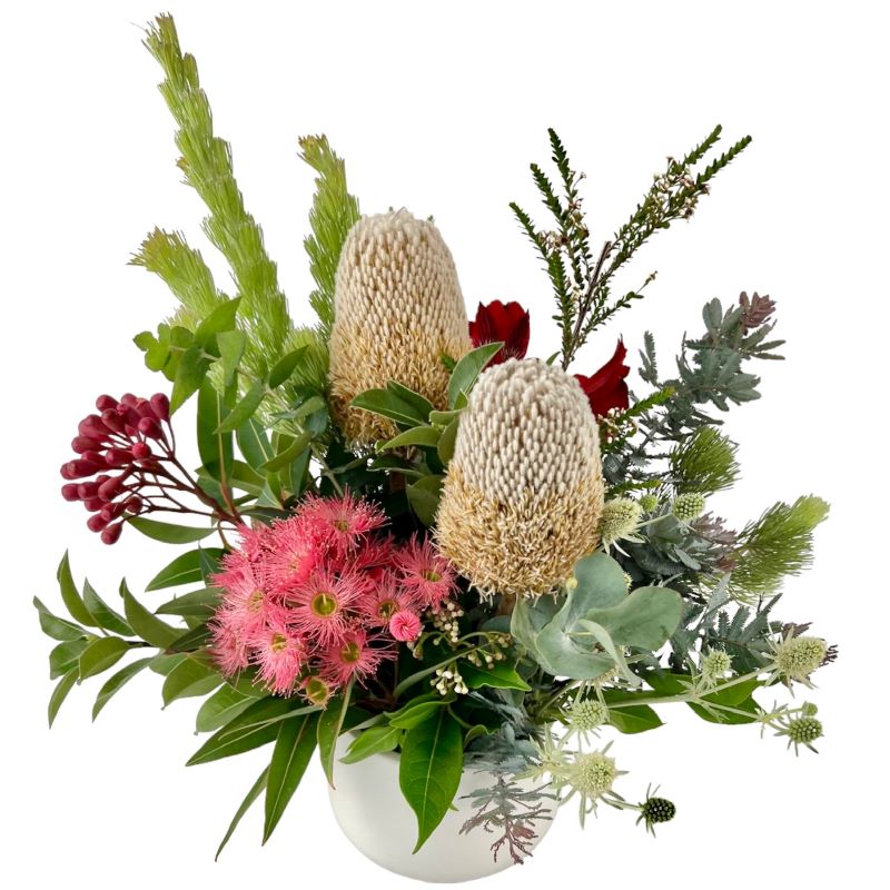 Mix of native protea, banksias and leucadendrons in a ceramic vase.