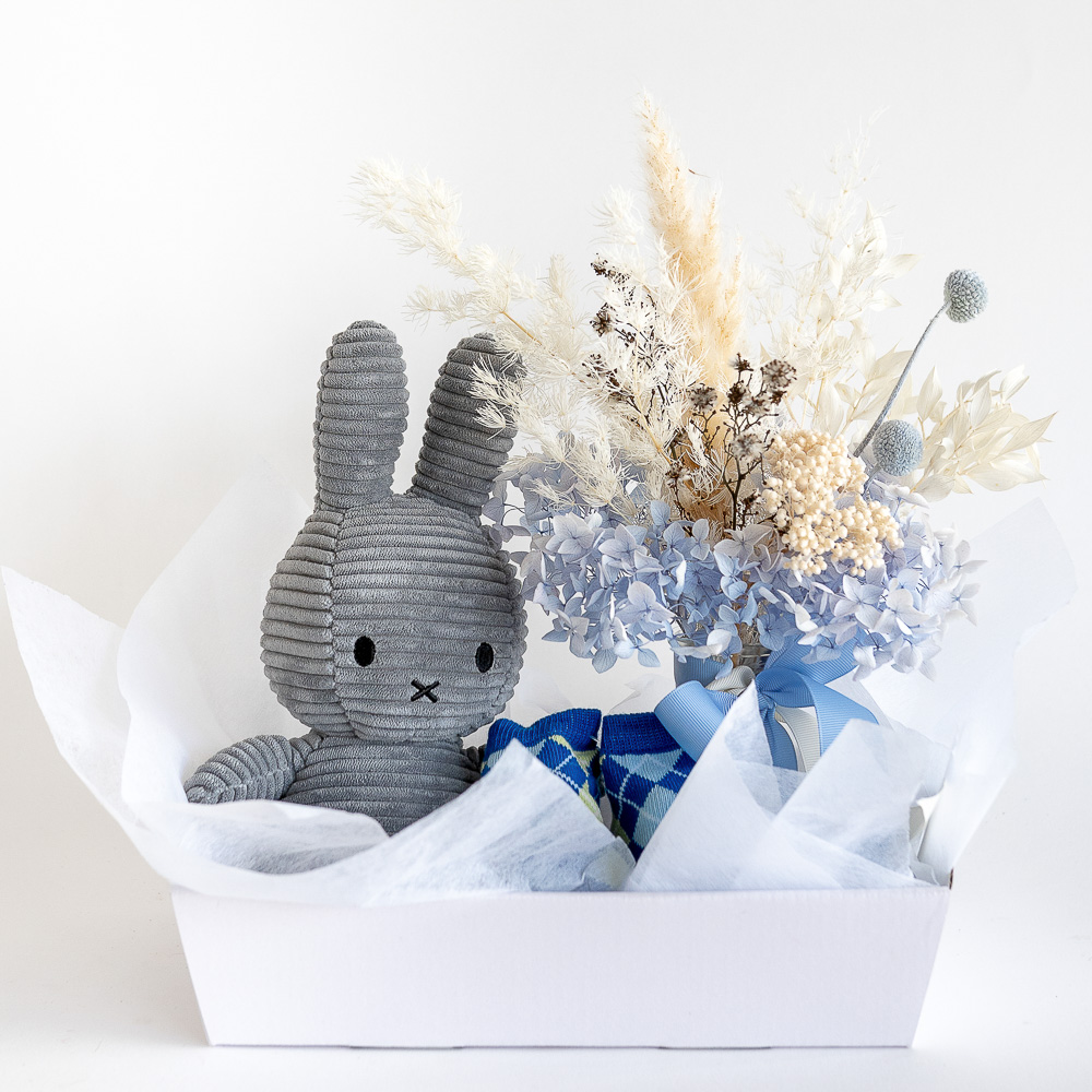 Dried flower arrangement with Grey Miffy Bunny soft toy and baby boy socks hamper.