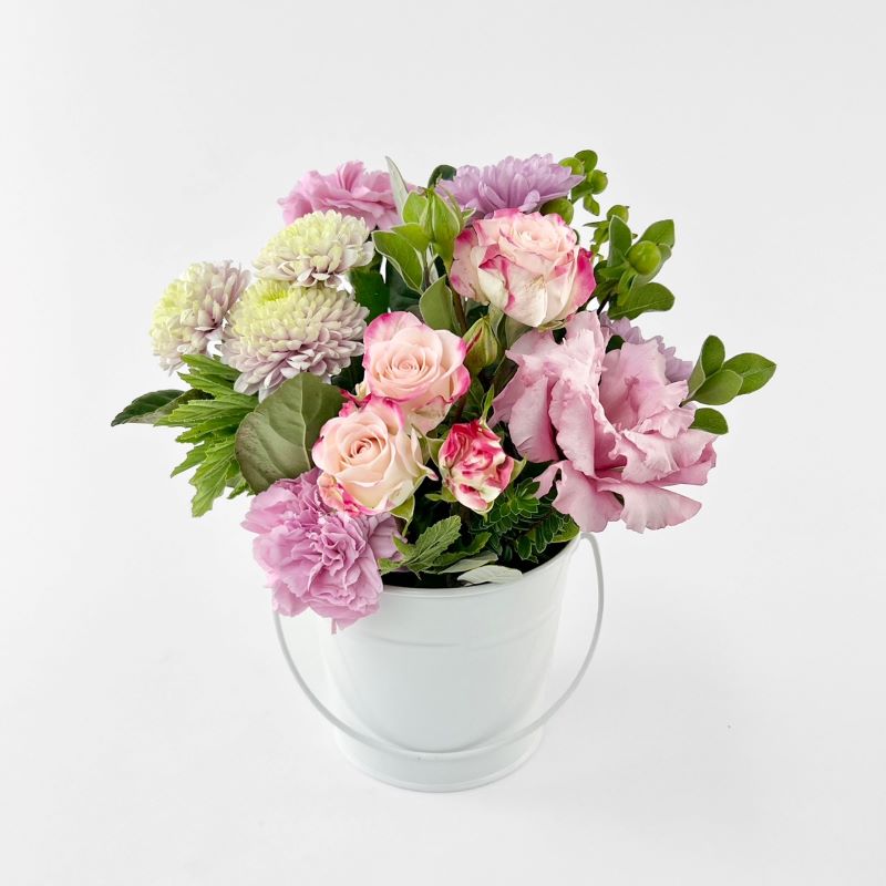 Seasonal soft pink flower mix arranged into a small white tin pot. Same day delivery in Melbourne.