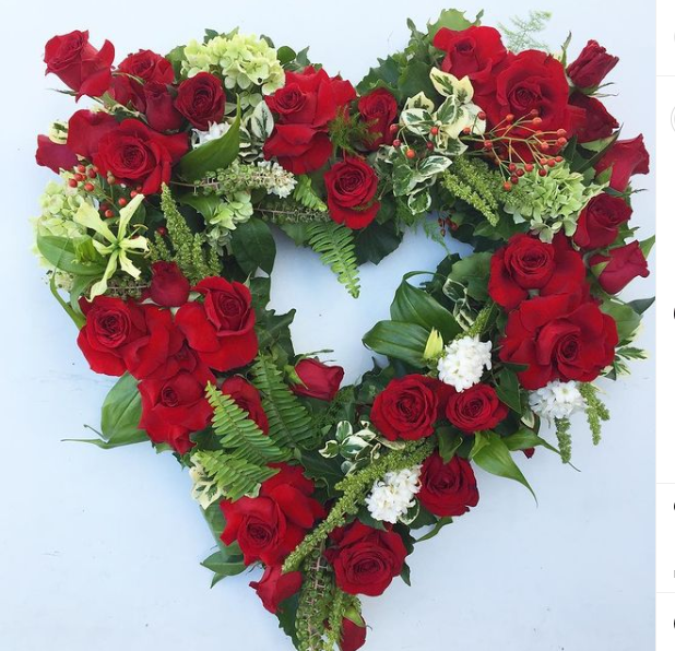 Love heart flower wreath featuring red roses and seasonal lush green foliage - Melbourne Metro delivery only