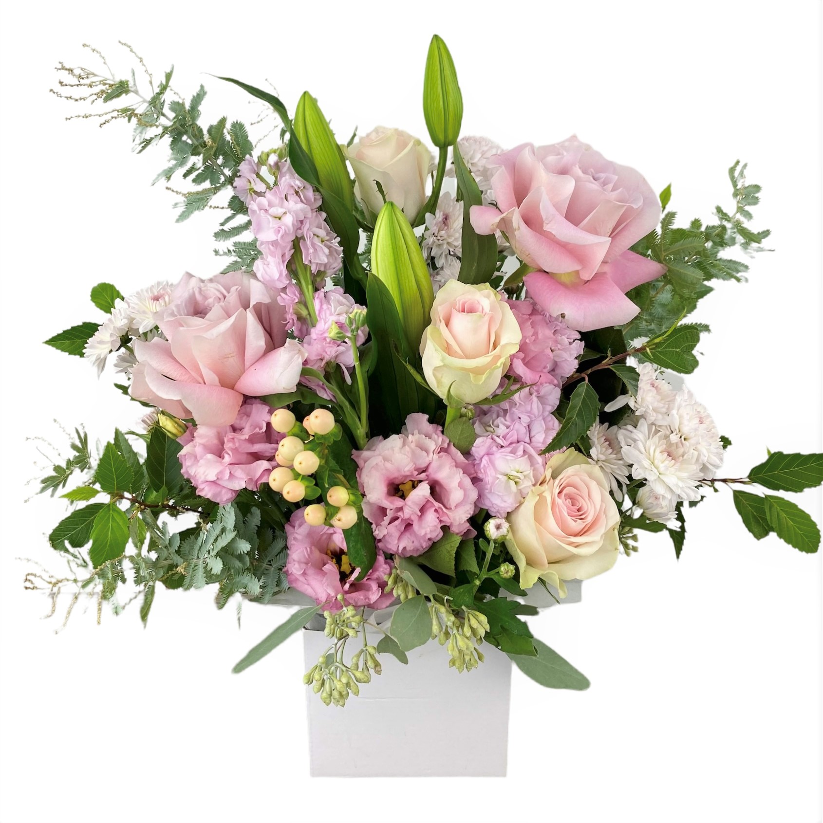 Flower arrangement featuring pale pink premium roses, oriental lily, chrysanthemums, lisianthus, stock & hypericum berry in white box.