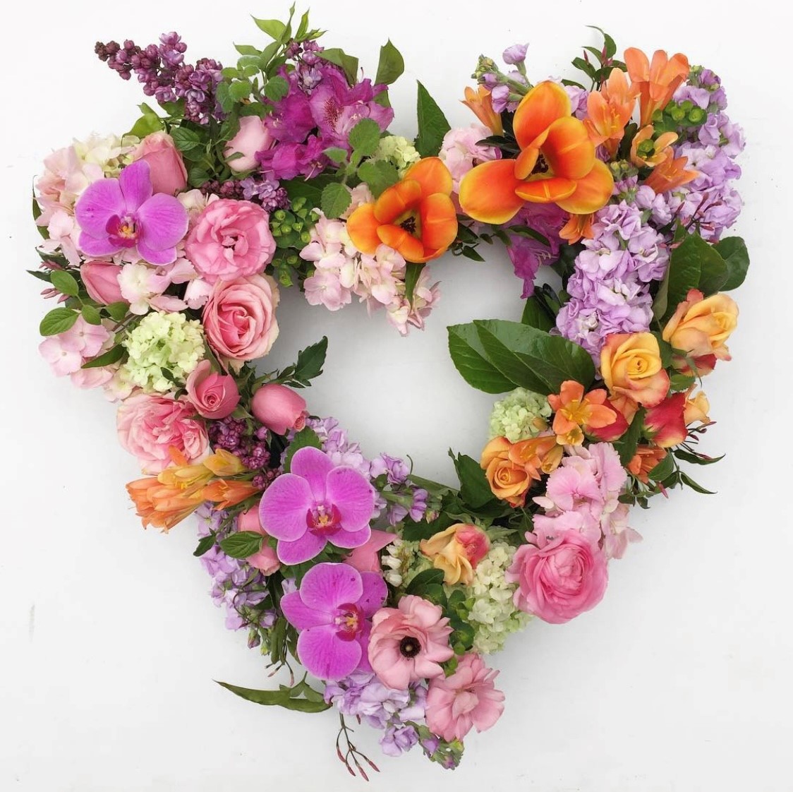 Colourful wreath in lilacs, pinks and oranges, available in round or heart shaped wreath. Melbourne delivery only. 1- 2 days notice.