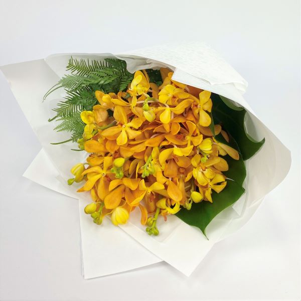 Orange vanda orchid bouquet with lush tropical leaves.