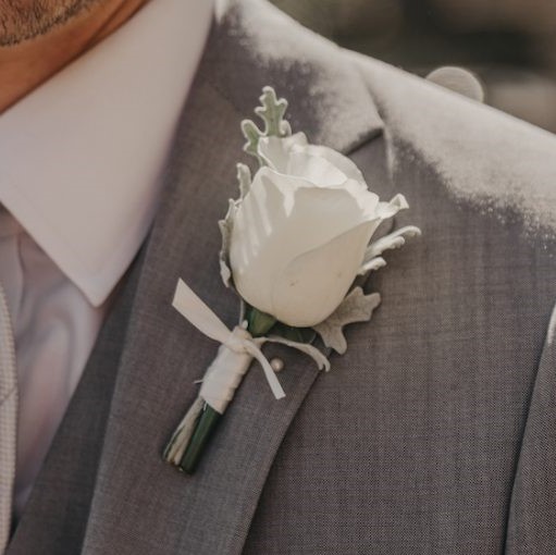 Single rose buttonhole accented with foliage.